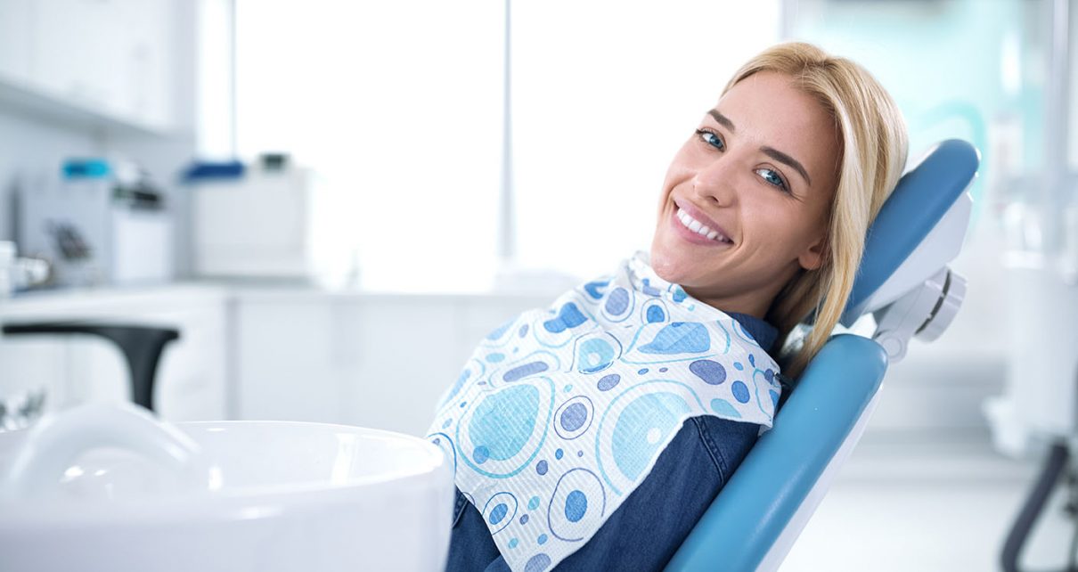 Uśmiechnięta i zadowolona kobieta u stomatologa
