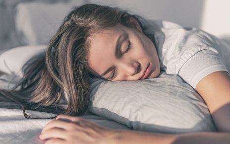 Piękna zmęczona kobieta odsypia ciężki tydzień w weekend na wygodnej poduszce