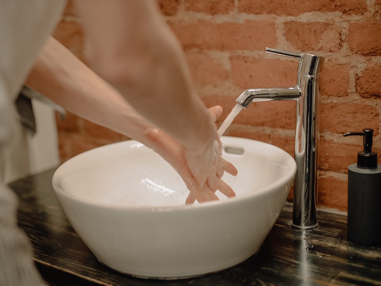 Kobieta myje ręce szarym mydłem