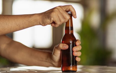 Mężczyzna otwiera butelke z piwem
