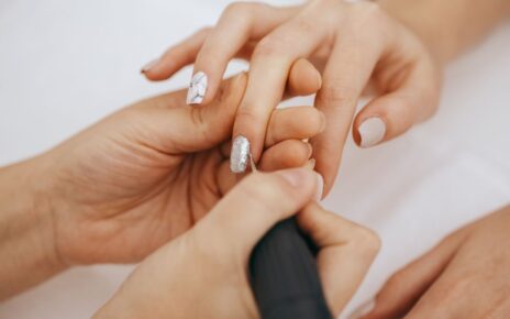Kobieta robiąć paznokcie korzysta z frezarki do paznokci