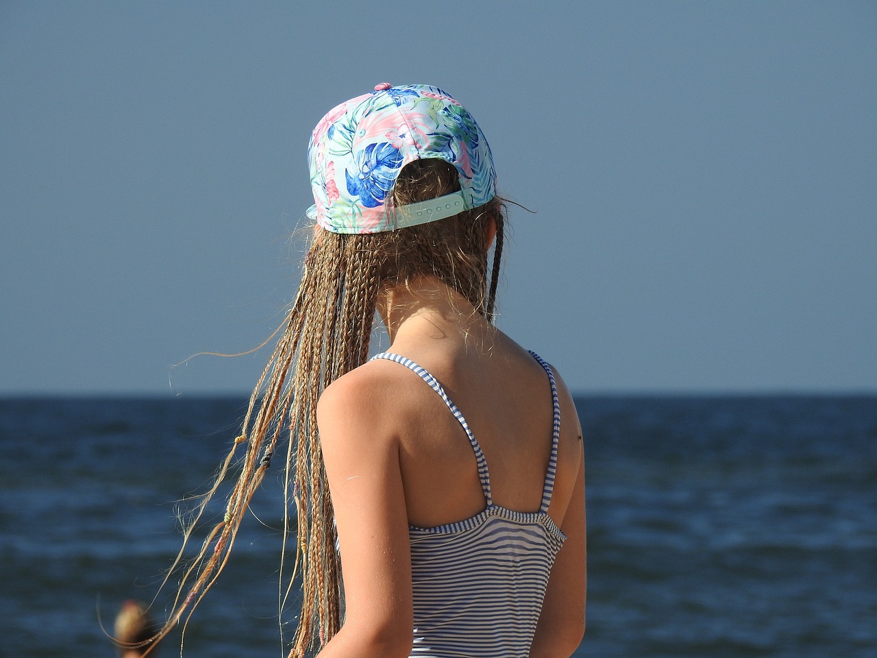 Dziewczynka z syntetycznymi warkoczykami w czapce