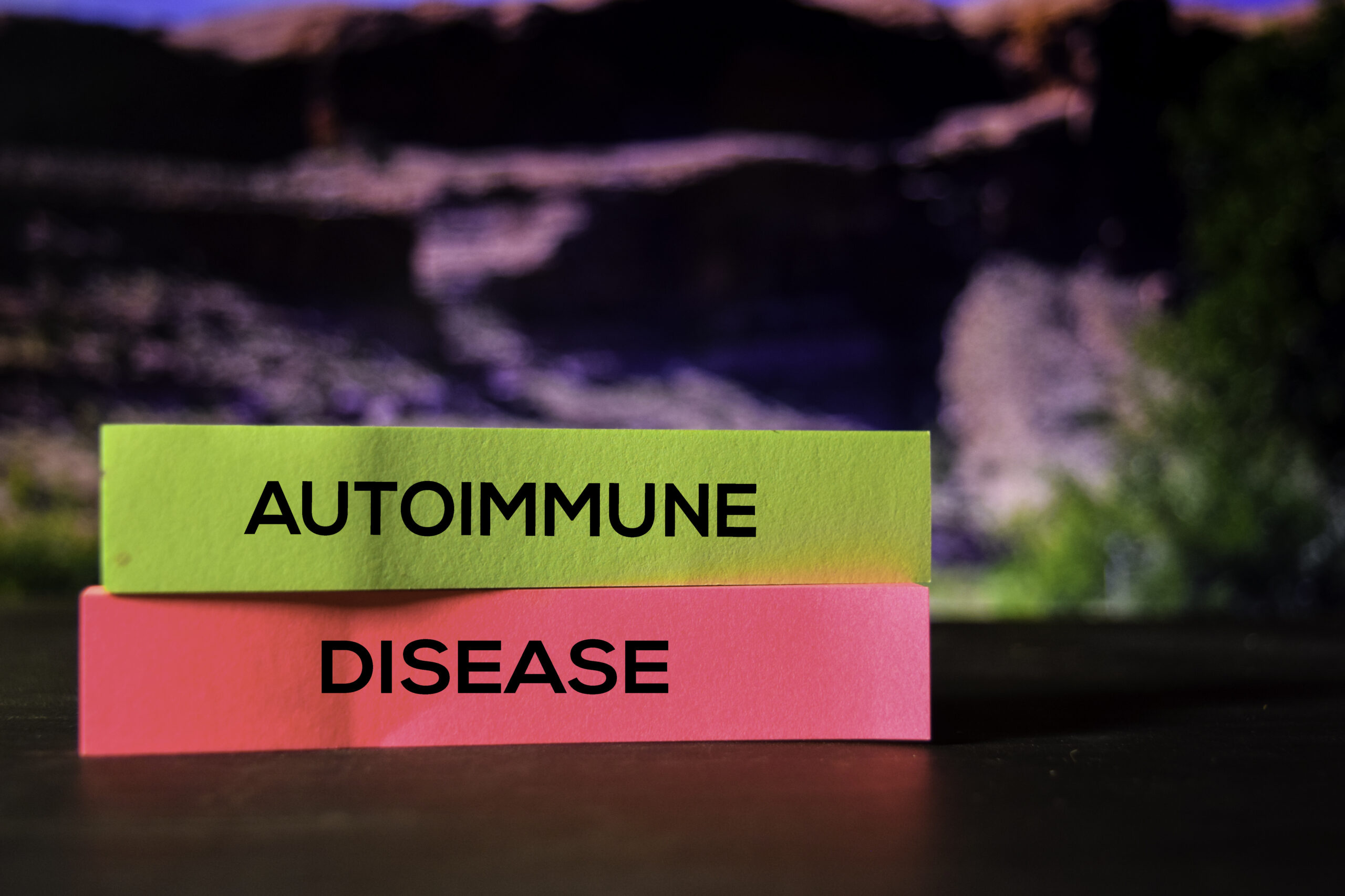 Ten ujmujący obrazek przedstawia napis "choroba autoimmunologiczna" zapisany na kolorowych karteczkach, co symbolicznie odzwierciedla złożoność tych schorzeń. Poprzez różne kolory karteczek, obrazek wskazuje na różnorodność chorób autoimmunologicznych oraz ich wpływ na organizm człowieka.