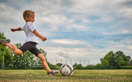 Chłopiec gra na boisku w piłkę nożną