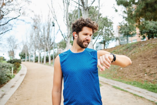 Mężczyzna biegający po parku ma na dłoni smartbanda