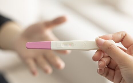Kobieta trzyma w dłoni negatywny test ciążowy