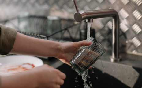 Kobieta myje naczynia wodą z kranu