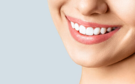 Kobieta z białymi zębami używa wybielającej pasty do zębów