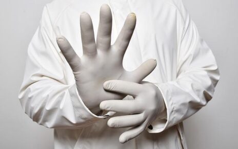 Lekarz w białych rękawiczkach na dłoniach