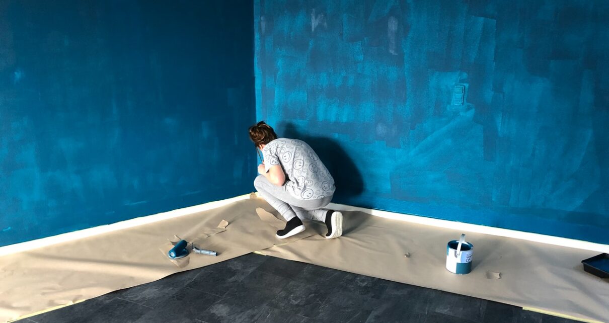 Kobieta maluje ściany w swoim domu na modny kolor