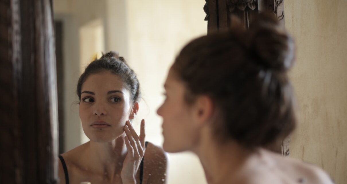 Kobieta ogląda swoją twarz w lustrze