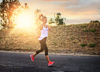 Kobieta biega mając przy sobie akcesoria sportowe