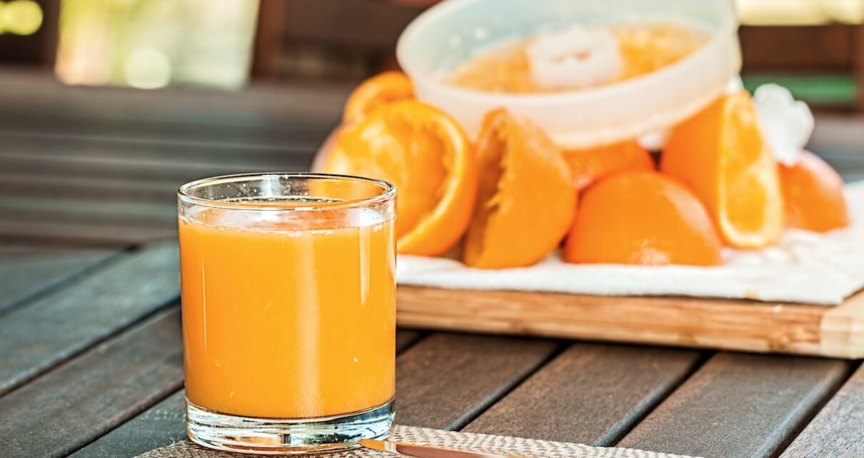 Zdrowy, świeżo wyciśnięty sok z pomarańczy stoi na stole