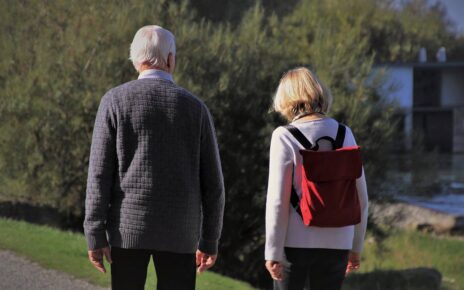 Kobieta która jest opiekunką osób starszych idzie ze starszym mężczyzną na spacer