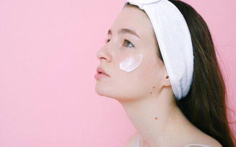 Kobieta nakłada na twarz pielęgnacyjny krem do twarzy