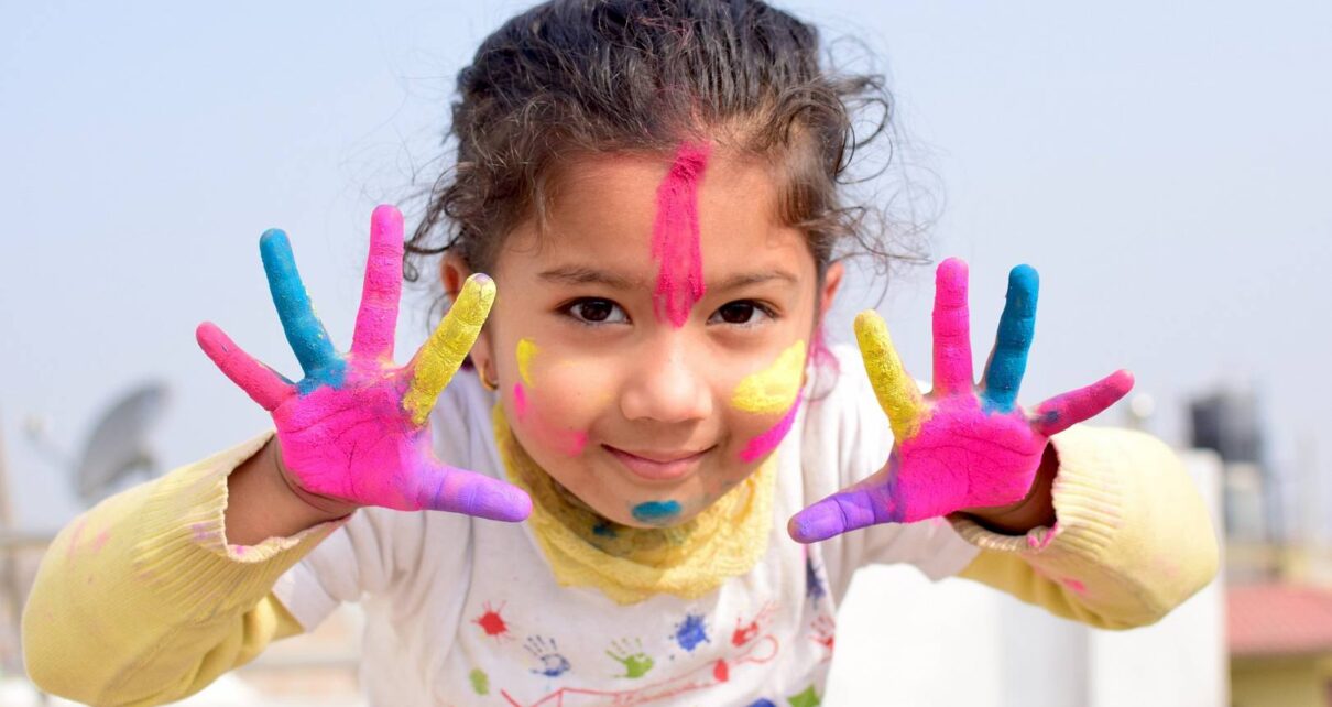 Dziewczynka ma na rękach i na twarzy farbę do malowania