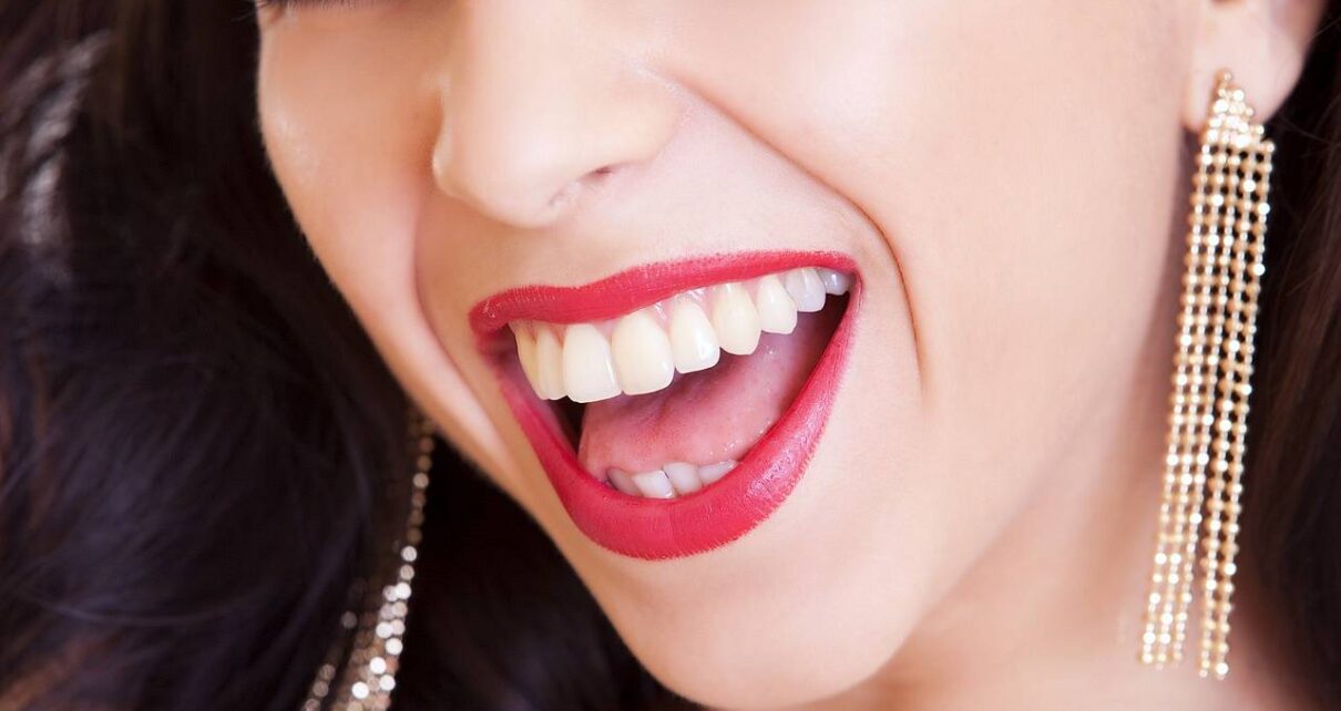 Kobieta z białymi i zadbanymi zębami uśmiecha się