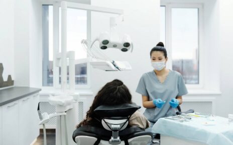 Stomatolog sprawdza zęby pacjentowi na fotelu