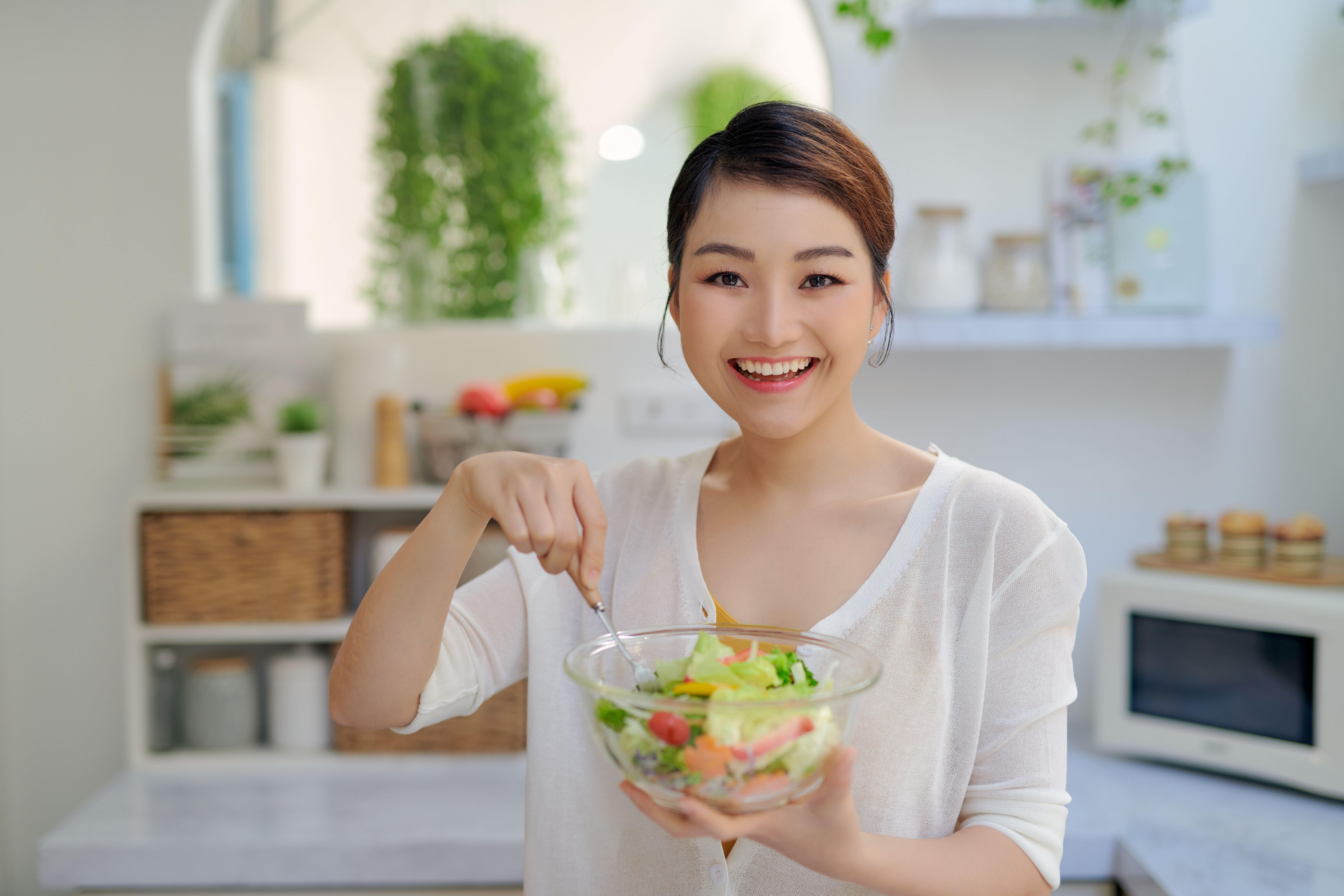 Dietetyk na NFZ z miseczką zdrowej sałatki uśmiechający się do zdjęcia