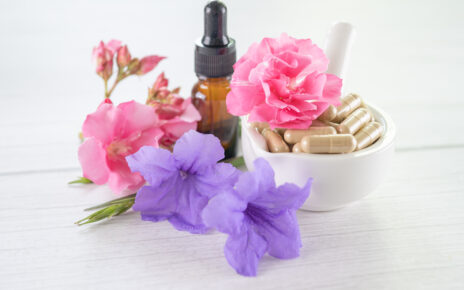 Na obrazku widoczny jest kwiatowy olejek, powszechnie stosowany w medycynie naturalnej, otoczony urokliwymi kwiatami. Olejek ten charakteryzuje się intensywnym aromatem i jest często wykorzystywany w celu poprawy samopoczucia oraz łagodzenia różnego rodzaju dolegliwości zdrowotnych.