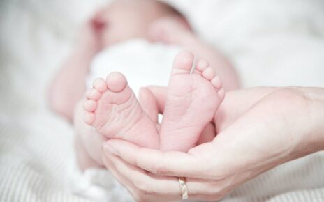 Kobieta trzyma stopy swojego nowo narodzonego dziecka