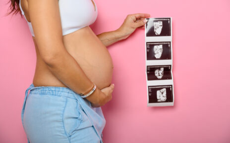 Na tym wzruszającym obrazku widzimy kobietę w ciąży, która trzyma przed sobą zdjęcia ultrasonograficzne swojego nienarodzonego dziecka. Jej spojrzenie jest pełne emocji i miłości, gdyż obrazki ukazują pierwsze wizualne połączenie z maleńkim życiem rozwijającym się w jej łonie. To piękna pamiątka i wyjątkowy sposób na zbliżenie się do swojego dziecka jeszcze przed jego narodzinami