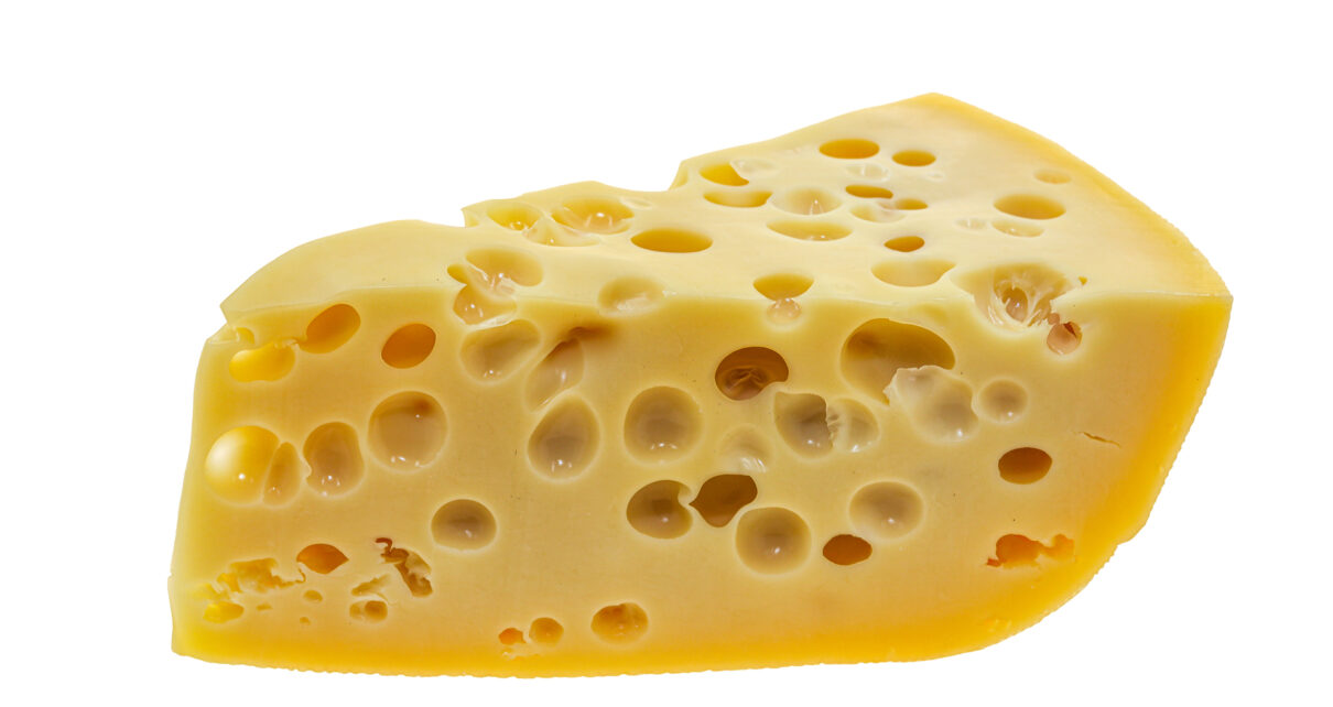 Na tym obrazku widać apetyczny domowy ser żółty z charakterystycznymi, równomiernie rozłożonymi dziurami, które dodają mu autentycznego uroku. Jego złocisty kolor w połączeniu z kremową konsystencją tworzy nieodparte wrażenie. Obrazek ilustruje, jak domowy ser żółty z dziurami może być nie tylko smaczny, ale także pięknie prezentujący się na talerzu, zachęcając do delektowania się jego wyjątkowym smakiem
